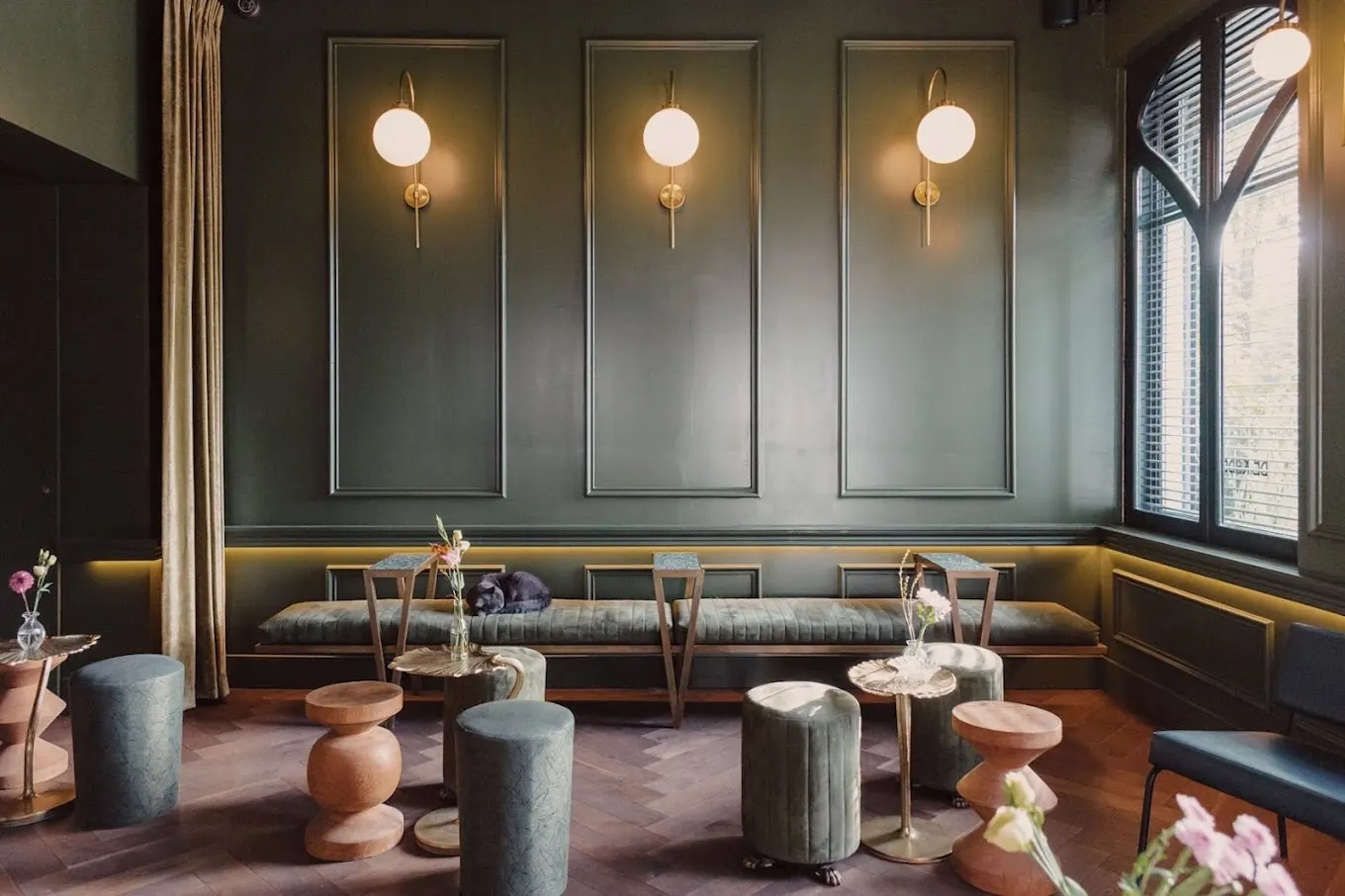 The De Kade lounge with brass wall lights and velvet stools